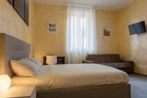 Leader Apartment 2 في ميلانو: غرفة نوم بسرير واريكة وتلفزيون