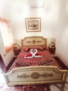 una camera da letto con un letto con due cigni sopra di Riad DAR BARBI a Marrakech
