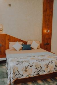 a bedroom with a bed with a white bedspread at Willow House Vagamon in Vagamon