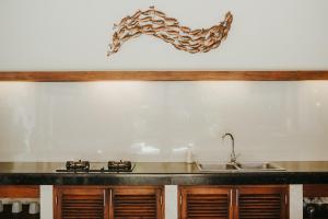 een keuken met een wastafel en een vis aan de muur bij ALOKA BAHARI Villas in Tejakula