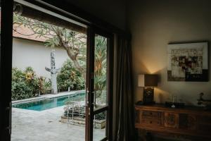 a room with a view of a swimming pool through a window at ALOKA BAHARI Villas in Tejakula