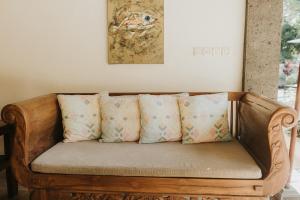 a wooden couch with pillows on it in a room at ALOKA BAHARI Villas in Tejakula