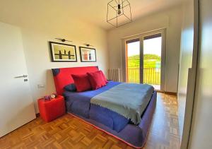 a bedroom with a large bed with red and blue sheets at La Vista dal Cielo in Monforte dʼAlba