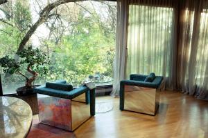 uma sala de estar com duas cadeiras e uma grande janela em Room12 House em Bucareste