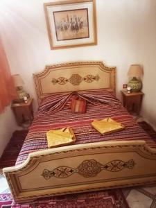 a bedroom with a bed with two yellow napkins on it at Riad DAR BARBI in Marrakesh