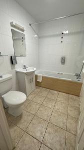 a bathroom with a toilet and a tub and a sink at Horseshoes cafe and lodge in Welbourn