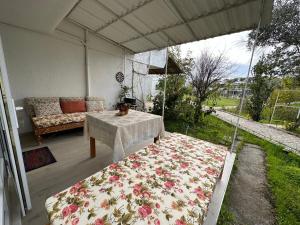 eine überdachte Veranda mit einem Sofa und einem Tisch in der Unterkunft Modernized Family Villa in Beach Site in Manavgat