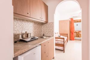 a kitchen with wooden cabinets and a counter top at Villa Voula in Perissa