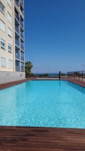 a large blue swimming pool next to a building at Seafront La Manga Apartment in La Manga del Mar Menor