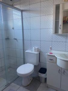a bathroom with a toilet and a shower and a sink at Teuthos Hotel in Teutônia