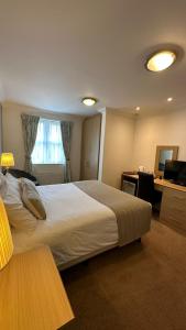 a hotel room with a large bed and a desk at Horseshoes cafe and lodge in Welbourn