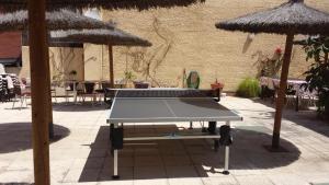 a ping pong table in a courtyard with umbrellas at Residencia Universitaria Tagaste in Barcelona