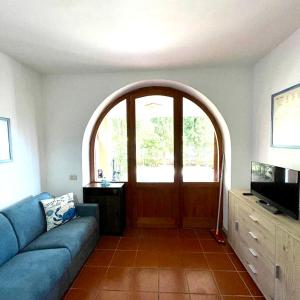 salon z niebieską kanapą i łukowymi drzwiami w obiekcie Trilocale Vista Mare Isola d'Elba w mieście Capo D'Arco