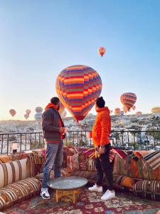 Un grupo de tres personas volando cometas sobre un sofá. en Pashahan Hotel, en Göreme