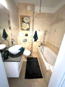 a bathroom with a tub and a toilet and a sink at Sea Promenade Luxury Apartment in Świnoujście