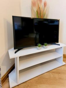 a flat screen tv on a white tv stand at Eagle homely apartment in Kettering