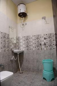 Un baño con lavabo, inodoro y espejo. en Sukhmanee Home Stay, en Amritsar