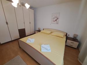 - une chambre avec un lit et 2 serviettes dans l'établissement Apartmani Dijana, à Rab