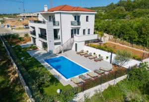 una vista aérea de una casa con piscina en Apartments Paola & Karla with pool, en Krk