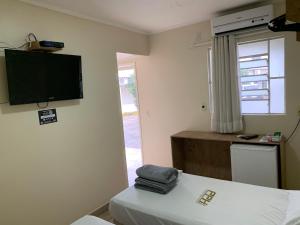 a room with a bed and a television on the wall at Pissin Plaza Hotel in Goiânia