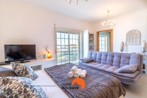 uma sala de estar com um sofá e uma televisão em #108 Old Town Seaview Studio with Pool, 60 mts Beach em Albufeira