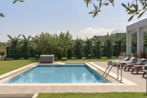 einen Pool im Hinterhof eines Hauses in der Unterkunft Agrielia Villas, featuring Heated Spa Whirlpool, By ThinkVilla in Pigianos Kampos