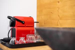a red coffee maker sitting on a table with glasses at Pefkon Suites in Afitos