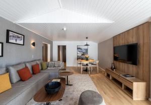 a living room with a couch and a tv at Victoria Hotel & Residence in Villars-sur-Ollon