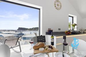 une salle à manger avec une table, des verres à vin et une fenêtre dans l'établissement Teign View at Grand Banks, à Teignmouth