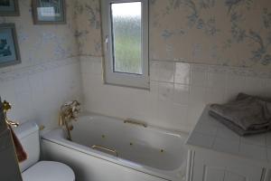 a bathroom with a tub and a toilet and a sink at Whitstable house with a view and 2 parking spaces in Kent