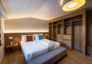 ein Schlafzimmer mit einem großen Bett in einem Zimmer in der Unterkunft Victoria Hotel & Residence in Villars-sur-Ollon