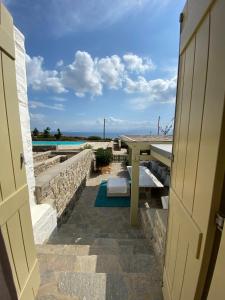 a door leading to a patio with a table and a pool at Delta Apartment in Chrissi Akti