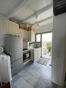 a kitchen with white appliances and a large window at Delta Apartment with Sea View and Pool in Chrissi Akti