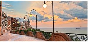 a street with street lights and the ocean at sunset at Abruzzo Holiday in Ortona