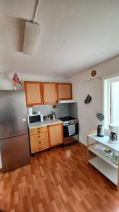 uma cozinha com um frigorífico em aço inoxidável e pisos em madeira em Tromso Coco Apartments in Center em Tromsø