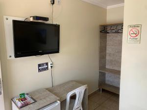 Habitación con TV de pantalla plana en la pared en Pissin Plaza Hotel, en Goiânia