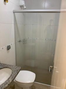 a bathroom with a shower with a toilet and a sink at Pissin Plaza Hotel in Goiânia