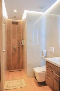 y baño con ducha, aseo y lavamanos. en Fori's rooms, en Himare