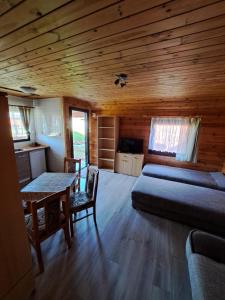 a bedroom with a bed and a table in a cabin at Domki letniskowe GOSIA in Żarnowska