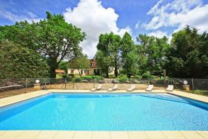 a swimming pool with lounge chairs and a house at Hostellerie du Causse in Gramat