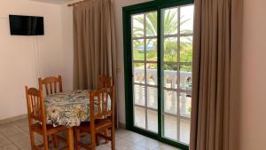a dining room with a table and chairs and a window at Apartamentos Villa Aurora in Valle Gran Rey