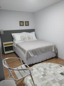 - une chambre avec un lit et une chaise dans l'établissement Gastaldon Suite, à Chapecó