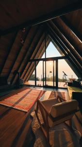 Tlos Nature Houses في Yaka: غرفة معيشة مع كرسي ونافذة كبيرة