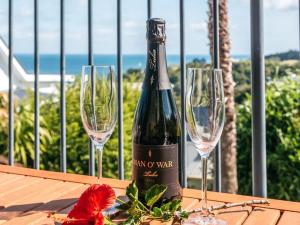 una botella de vino sentada en una mesa con dos copas de vino en Palm Beach Oasis, Double Kayak, WiFi, SKYTV & possibly a Car!, en Palm Beach