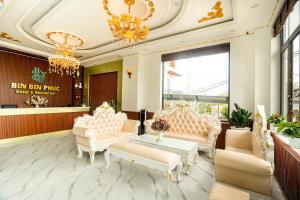 un vestíbulo con muebles blancos y una lámpara de araña en BinBin Phúc Dalat Hotel, en Da Lat