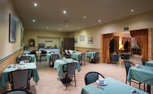 a restaurant with tables and chairs with green table cloth at Anne De Beaujeu in Gien