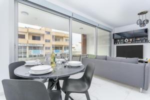 uma sala de jantar com uma mesa e cadeiras e um sofá em Mirage 2-BR Apartment in Larnaca em Lárnaca