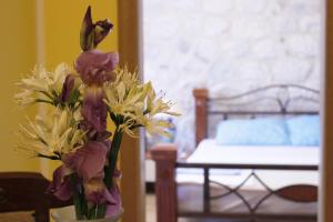 a vase filled with white and purple flowers on a table at Apartments Jelena in Kotor