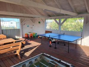 una habitación con 2 mesas de ping pong y una piscina en Domki GAMA en Gąski