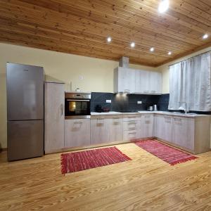 cocina con electrodomésticos de acero inoxidable y techo de madera en Harcons Home, en Katouna
